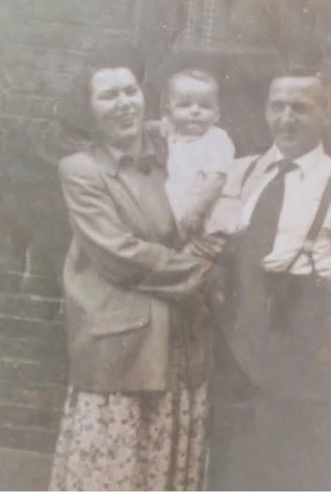 Faded sepia photograph of a family of three, soft and yellowed, before restoration